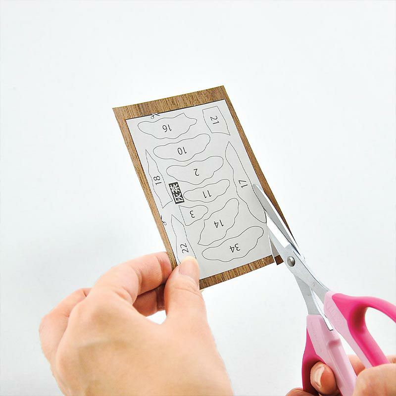 天然木のシートをはさみで切り下絵に貼ります