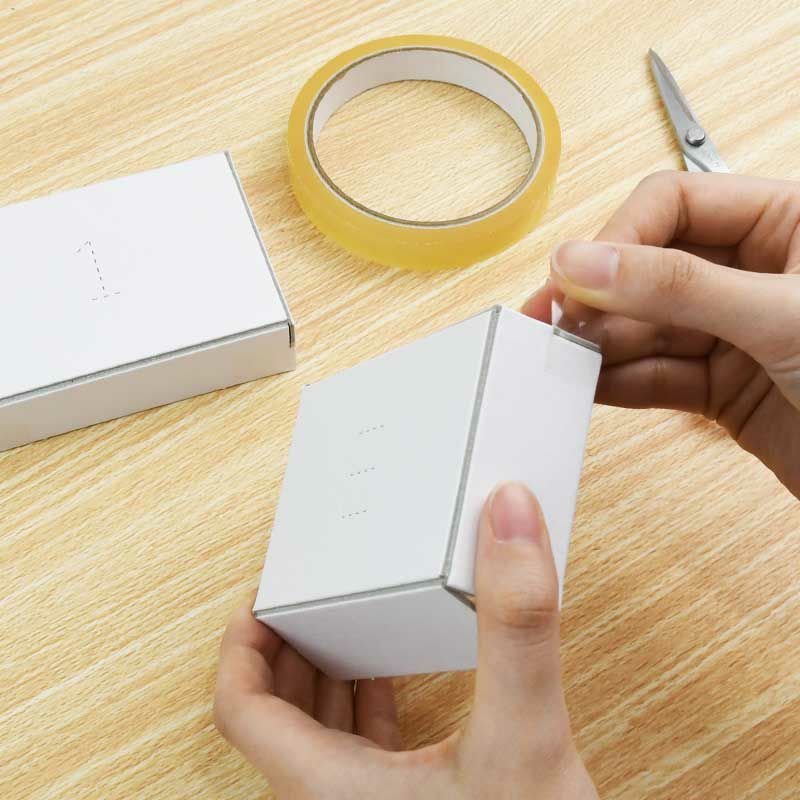 フタと本体をセロテープで貼って組み立て、周りにスティックのりで用紙を貼ります